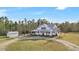 Aerial view of a white farmhouse on a large lot with a shed at 153 Ashby Cove Ln, New Smyrna Beach, FL 32168