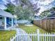 Landscaped backyard with circular patio and wooden fence at 205 Mary Ave, New Smyrna Beach, FL 32168