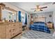 Comfortable bedroom with ceiling fan, dresser, and blue plaid bedding at 2919 Pine Tree Dr, Edgewater, FL 32141