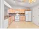 Kitchen with light wood cabinets and white appliances at 3313 Celena Cir, St Cloud, FL 34769