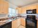 Modern kitchen with black appliances and wood cabinets at 3606 S Peninsula Dr # 404, Port Orange, FL 32127