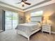 Main bedroom with white bed frame and access to the pool at 383 Leoni St, New Smyrna Beach, FL 32168