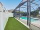 Screened-in pool area with artificial turf at 383 Leoni St, New Smyrna Beach, FL 32168