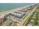 Aerial view of beachfront community with pools, tennis court, and ocean views at 4151 S Atlantic Ave # 112, New Smyrna Beach, FL 32169