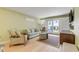 Living room with light walls, comfy seating and access to a patio at 4151 S Atlantic Ave # 112, New Smyrna Beach, FL 32169