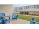 Private patio with blue Adirondack chairs, overlooking a lawn and pool at 4151 S Atlantic Ave # 112, New Smyrna Beach, FL 32169