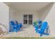 Private patio with multiple blue Adirondack chairs at 4151 S Atlantic Ave # 112, New Smyrna Beach, FL 32169