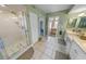 Main bathroom with shower, double vanity and access to bedroom at 4670 Links Village Dr # C402, Ponce Inlet, FL 32127