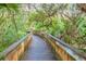 Nature trail boardwalk winding through lush foliage at 4670 Links Village Dr # C402, Ponce Inlet, FL 32127