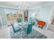 Charming dining room with glass table and teal chairs at 4670 Links Village Dr # C402, Ponce Inlet, FL 32127