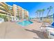 Relaxing community pool area with lounge chairs and building view at 4670 Links Village Dr # C402, Ponce Inlet, FL 32127