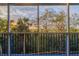 Screened-in balcony with sunset views of palm trees and lush greenery at 5300 S Atlantic Ave # 9-304, New Smyrna Beach, FL 32169