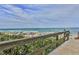 View of the beach from the Oceanwalk boardwalk with beachgoers and colorful umbrellas at 5300 S Atlantic Ave # 9-304, New Smyrna Beach, FL 32169