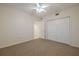Empty bedroom with carpet, ceiling fan, and white closet doors at 5300 S Atlantic Ave # 9-304, New Smyrna Beach, FL 32169