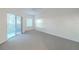 Spacious bedroom with carpet flooring and sliding glass door to balcony at 5300 S Atlantic Ave # 9-304, New Smyrna Beach, FL 32169