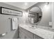 Modern bathroom with white vanity, marble countertop, and round mirror at 5499 S Atlantic Ave # 905, New Smyrna Beach, FL 32169