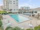 Community pool with lounge chairs and tennis courts at 5499 S Atlantic Ave # 905, New Smyrna Beach, FL 32169