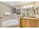 Bathroom boasts a corner jacuzzi tub, granite countertops, and light wood cabinets at 701 N Atlantic Ave # 203, New Smyrna Beach, FL 32169