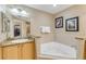 Spa-like bathroom with corner jacuzzi tub, granite vanity, and walk-in shower at 701 N Atlantic Ave # 203, New Smyrna Beach, FL 32169