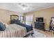 King bedroom with dark wood furniture, ceiling fan, and access to balcony at 701 N Atlantic Ave # 203, New Smyrna Beach, FL 32169