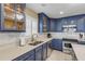 Modern kitchen with blue cabinets, stainless steel appliances, and white backsplash at 701 N Atlantic Ave # 203, New Smyrna Beach, FL 32169