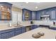 Modern kitchen featuring blue cabinetry, stainless steel appliances, and a large island at 701 N Atlantic Ave # 203, New Smyrna Beach, FL 32169