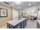 Eat-in kitchen with blue cabinetry, quartz countertops, and access to living area at 701 N Atlantic Ave # 203, New Smyrna Beach, FL 32169