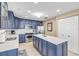 Spacious kitchen with blue cabinets, stainless steel appliances, and quartz countertops at 701 N Atlantic Ave # 203, New Smyrna Beach, FL 32169