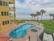 Oceanfront pool with lounge chairs and spa at 701 N Atlantic Ave # 203, New Smyrna Beach, FL 32169