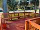 Wooden deck with built-in seating overlooks a tree-lined street at 801 Sandpiper Ave, New Smyrna Beach, FL 32169