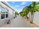 Backyard with a paved pathway, white fence, and tropical landscaping at 833 E 26Th Ave, New Smyrna Beach, FL 32169