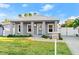 Modern single-story home with a light blue door, landscaped front yard, driveway, and a metal roof at 833 E 26Th Ave, New Smyrna Beach, FL 32169