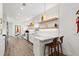 Modern white kitchen with chevron tile backsplash, stainless steel appliances, and floating shelves at 833 E 26Th Ave, New Smyrna Beach, FL 32169