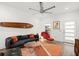 Living room featuring a dark gray couch, red chair, surfboard decor, and wood floors at 833 E 26Th Ave, New Smyrna Beach, FL 32169