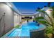 Tranquil pool and spa with blue mosaic tile, lush landscaping, and outdoor shower at 833 E 26Th Ave, New Smyrna Beach, FL 32169