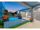 Modern pool and spa with blue mosaic tile, lush landscaping, and a covered patio at 833 E 26Th Ave, New Smyrna Beach, FL 32169
