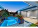 Inviting pool and spa with blue mosaic tile and lush landscaping at twilight at 833 E 26Th Ave, New Smyrna Beach, FL 32169