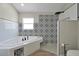 Bathroom with a walk-in shower, soaking tub, and patterned tile at 886 Matthews Ave, New Smyrna Beach, FL 32169