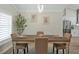 Elegant dining room with wood table, four chairs, and a stylish light fixture at 886 Matthews Ave, New Smyrna Beach, FL 32169