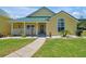 Inviting yellow house with a green roof and a spacious front porch at 886 Matthews Ave, New Smyrna Beach, FL 32169