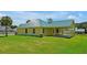 Single-story house with a green metal roof and large backyard at 886 Matthews Ave, New Smyrna Beach, FL 32169