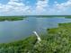 Aerial view of a peaceful waterfront scene with a dock at 116 Cedar Dunes Dr, New Smyrna Beach, FL 32169