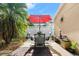 Outdoor patio with seating area, red umbrella, and brick paving at 210 Victoria Commons Blvd, Deland, FL 32724