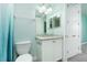 Small bathroom with white vanity, granite countertop, and teal walls at 3 Riverwalk Dr # 303, New Smyrna Beach, FL 32169