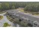 Aerial view of a townhome community with gray roofs, balconies, and surrounding trees at 3414 Medici Blvd, New Smyrna Beach, FL 32168