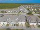 Aerial view of a community with townhomes, parking areas, and trees at 3414 Medici Blvd, New Smyrna Beach, FL 32168