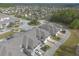Aerial view of townhomes and surrounding neighborhood with a small lake and trees at 3414 Medici Blvd, New Smyrna Beach, FL 32168