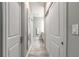 Hallway leading to a bathroom with white double doors, a large mirror, and tiled floor at 3414 Medici Blvd, New Smyrna Beach, FL 32168