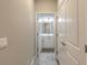 Hallway leading to a bathroom with white vanity and tiled flooring at 3414 Medici Blvd, New Smyrna Beach, FL 32168
