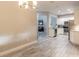 Dining room with tile flooring, chandelier and adjacent white kitchen with stainless steel appliances at 3414 Medici Blvd, New Smyrna Beach, FL 32168